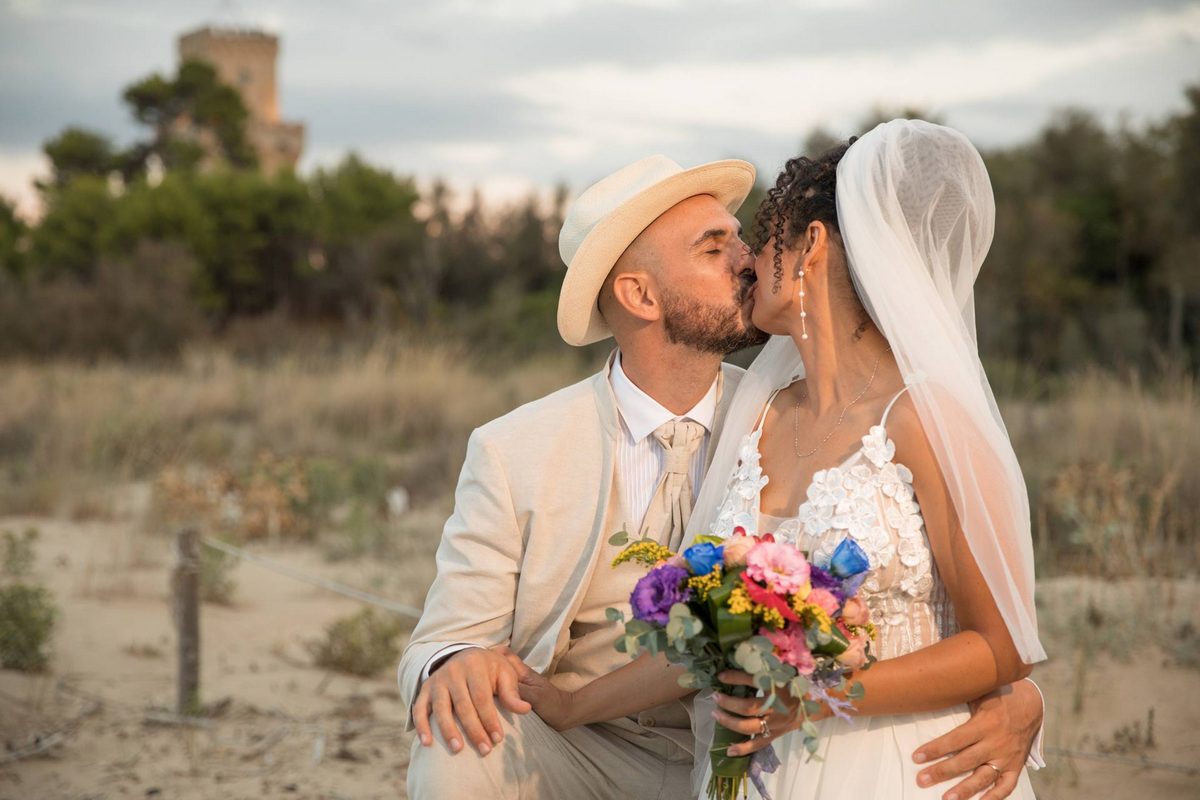 Baciandosi con lo sfondo della Torre di Cerrano - Pineto - bellissimo Abruzzo - Fotografo di matrimonio Pescara